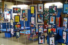 a room filled with paintings and pictures hanging from the ceiling