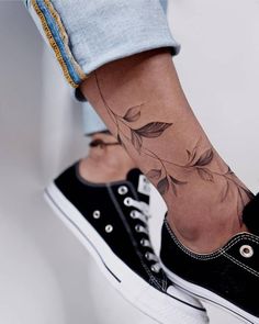 a woman's foot with a flower tattoo on her left ankle and the bottom part of her leg