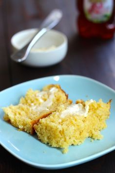 two pieces of cornbread on a blue plate next to a bowl of ketchup