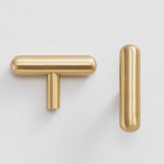 two gold colored handles on a white surface