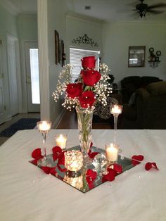 a vase with roses and candles on a table