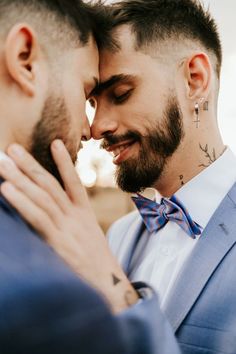 two men in suits and bow ties are looking at each other with their eyes closed