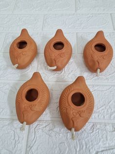 four brown vases sitting on top of a white table