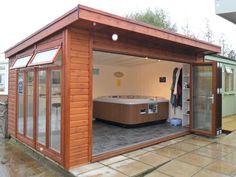 a wooden building with a hot tub in the center and glass doors on both sides