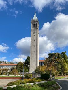 a tall tower with a clock on it's side in the middle of a park