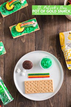 a white plate topped with crackers next to green and yellow snacks on top of a wooden table