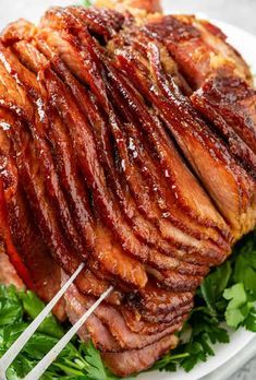 a large piece of meat sitting on top of a white plate with chopsticks