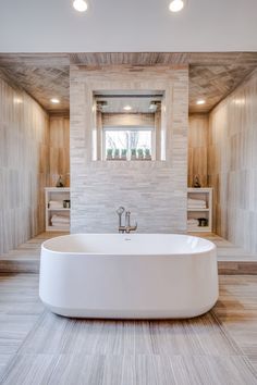 a large white bathtub sitting in the middle of a bathroom next to a window