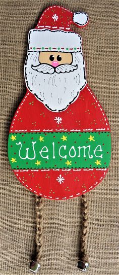 a wooden sign with a santa clause on it's face and the words welcome