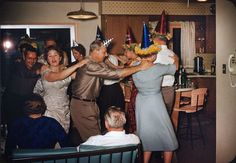 a group of people standing around each other at a party