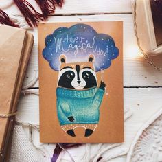 a card with a raccoon wearing a sweater