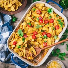 a casserole dish with tortilla shells and tomatoes