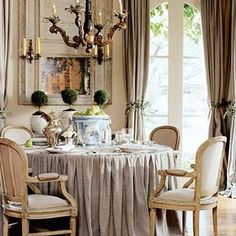 a dining room table with two chairs and a chandelier hanging from the ceiling