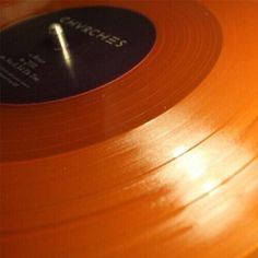 an orange vinyl record sitting on top of a table