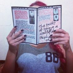 a woman holding up an open book with writing on it's face and hands