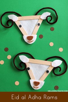 two deer head made out of popsicle sticks on top of a green surface with polka dots