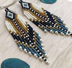 a pair of beaded earrings on top of a wooden table