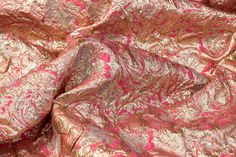 a pink and gold fabric with metallic foil on it's edges, as well as an intricate design