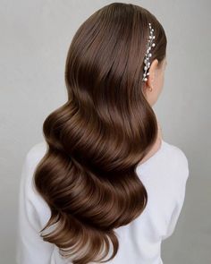 a woman with long brown hair wearing a headpiece in the shape of a flower