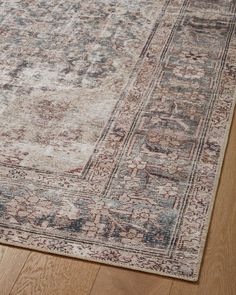 a large area rug with an ornate design on the top and bottom, in light brown tones