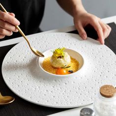 a white plate topped with food on top of a table next to utensils