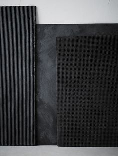 two pieces of black paper sitting next to each other