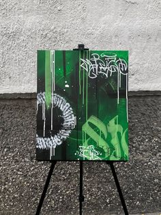 an easel with graffiti on it sitting in front of a wall