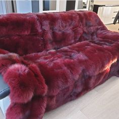 a red couch sitting on top of a hard wood floor