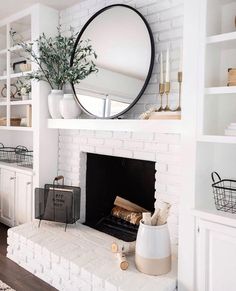 a living room filled with furniture and a fire place in front of a white brick fireplace