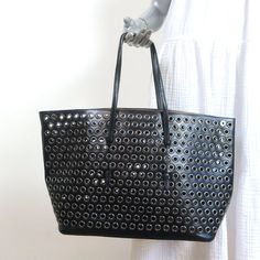 Alaia Mina Grommet Tote Black Leather Large Shoulder Bag Gently Usd. Good Condition. No Major Flaws, Light Wear On Bottom Corners And Straps. White Smudges On Pouch. Light Scratching On Bottom Studs. Does Not Come With Dustbag. Bag Height 11.75" Bag Length 14" At Base;19.25" At Widest Bag Depth 6.75" Strap Drop 7.75" Alaia Mina, Alaia Bag, Large Shoulder Bags, Womens Tote Bags, Dust Bag, Black Leather, Pouch, Shoulder Bag, Leather