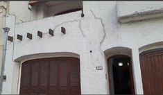 a white building with brown doors and windows