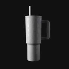 a white cup with a straw sticking out of it's side on a black background