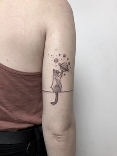 a woman's arm with a cat tattoo on the left side of her arm