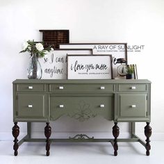 a green dresser with flowers and pictures on top