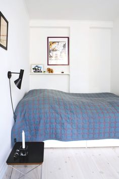 a bed sitting in a bedroom next to a wall mounted clock and pictures on the wall