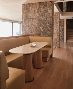 there is a table with two bowls on it in the middle of a room that has wood flooring