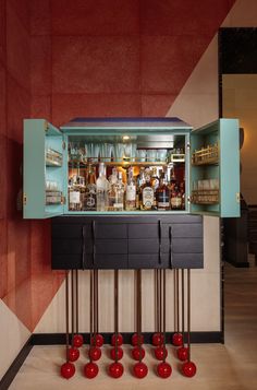 an old fashioned bar with lots of liquor bottles and red balls on the floor in front of it