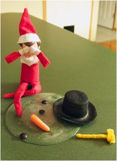 an elf sitting on top of a glass plate next to a carrot and black hat