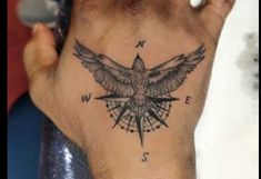 a person's hand with a bird on it and compass tattooed on the palm