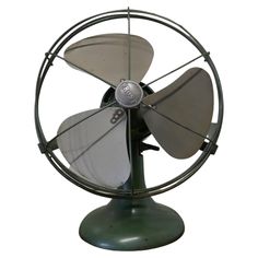 an old fashioned metal fan sitting on top of a table