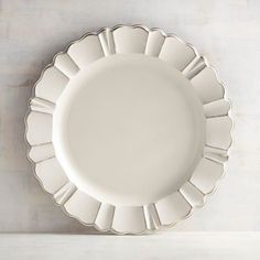 a white plate sitting on top of a counter next to a knife and fork in front of a wall