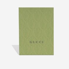 a green gucci notebook with the word gucci in black on it's cover