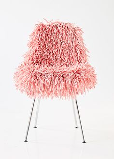 a pink chair that is sitting on some metal legs and it looks like something out of space