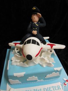 a birthday cake with a toy pilot on top