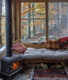 a couch sitting in front of a window next to a wood burning stove top oven