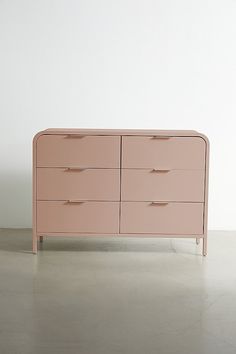 a pink dresser sitting on top of a white floor