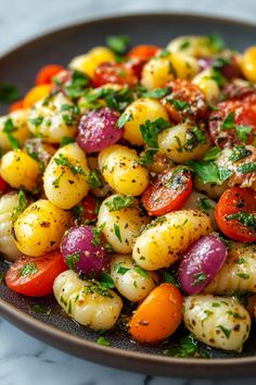 Colorful gnocchi salad with cherry tomatoes and fresh herbs in a bowl.