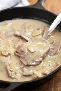 a skillet filled with meat and mushroom gravy