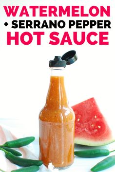 watermelon and serrano pepper hot sauce in a bottle with green peppers around it