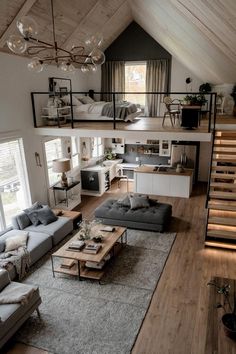 a living room filled with furniture next to a loft style kitchen and dining room area